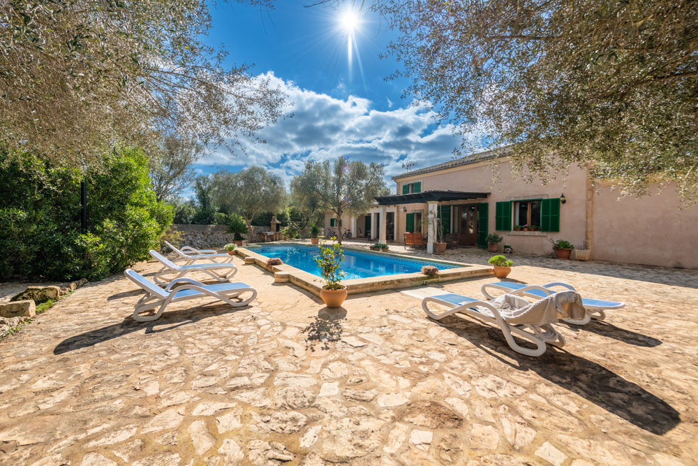 Pool der Finca von Vida Libre auf Mallorca in der Sonne, im Hintergrund das Finca-Gebäude